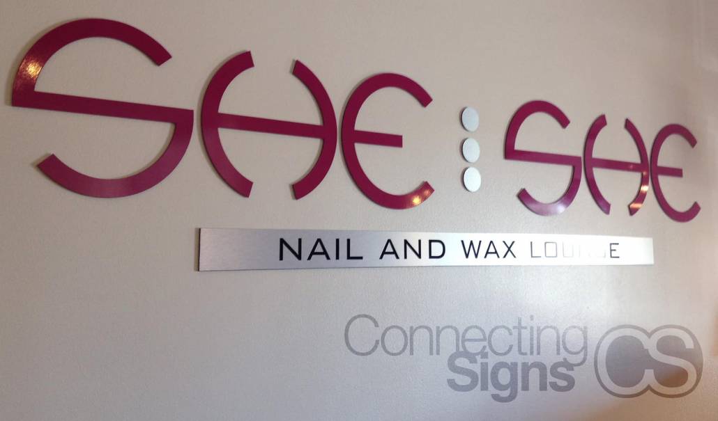 Nail and wax lounge logo hung on wall