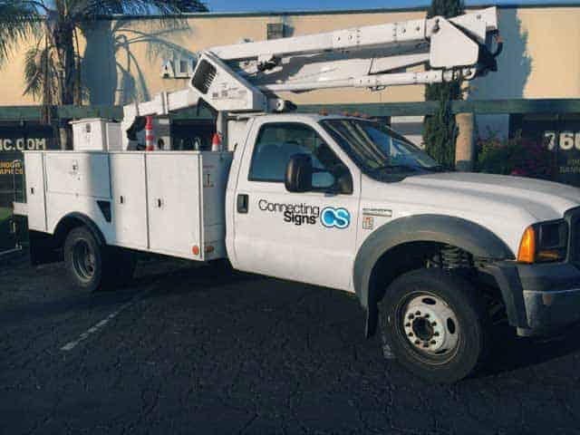 white bucket truck with connecting signs logo on the doors